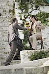 Businessman giving businesswoman flowers