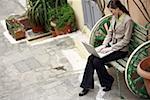 Businesswoman with laptop on a bench