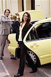 Businessman and woman loading taxi