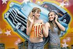 Deux adolescents femmes posant dans le parc d'attractions