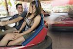 Teenage couple in bumper car in amusement park