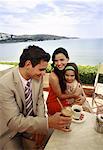 Couple with daughter at seaside cafe table
