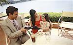 Couple avec fille à table de café de bord de mer