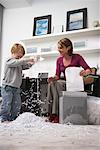 Woman and Boy Playing with Shredded Paper in Home Office