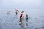 Famille à la plage, jouer dans l'eau