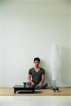 Serious young man sitting on floor, looking at camera