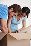 Couple Looking through Box in New Home