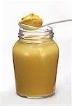 Un pot de moutarde jaune avec cuillère