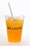 Orange juice in plastic tumbler with straw