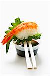 Nigiri Sushi mit Garnelen und Shiso Blatt an Sojasauce
