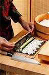 Preparing rolled sushi with cucumber