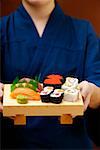 Person serving sushi platter