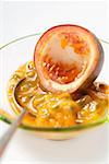 Spooning out passion fruit flesh (Purple granadilla)