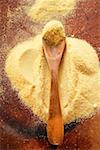 Polenta with wooden spoon on wooden background