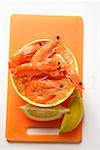 Shrimps in bowl with ice cubes, lemon wedges