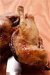 Roast pigeon, halved, on knife