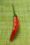 Red chili pepper on green background