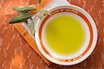 Olive oil in bowl on napkin, olive branch