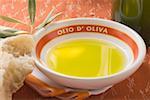 Olive oil in bowl on napkin, olive branch, white bread