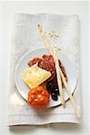 Salami, fromage, olives, tomates et grissini sur plaque