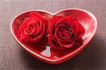 Red roses in heart-shaped bowl