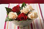 Roses in bowl on striped tablecloth