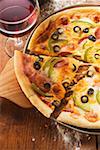 Pizza au fromage, salami, poivrons & olives, verre de vin rouge