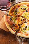 Pizza with cheese, salami, peppers & olives, glass of red wine