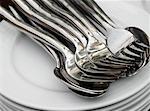 Pile of plates with spoons and forks