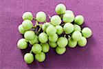 Green baby aubergines on purple background