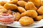 Viele Hühner-Nuggets mit Ketchup auf Platte