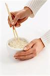 Woman’s hands holding chopsticks in a bowl of rice (2)