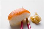 Nigiri sushi au saumon sur les baguettes et préservé au gingembre