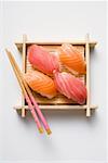 Nigiri sushi with chopsticks on bamboo mat