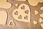Cut-out heart-shaped biscuits on baking parchment