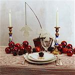 Red baubles and felt angels on Christmas table