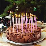 Chocolate cake with many burning candles