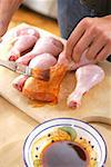 Brushing chicken thighs with marinade