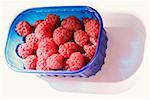 Raspberries in a blue plastic container