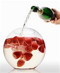 Pouring sparkling wine into strawberry punch