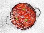 Peppers in a colander being sprayed with water