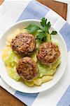 Burgers on potato and cucumber salad