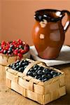 Blueberries in a basket and small bowl of mixed berries