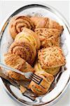 Assorted Danish pastries on silver platter with cake tongs