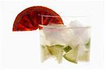 Mineral water with lime wedges, ice cubes and blood orange