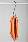 Two pairs of frankfurters on a hook