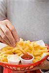 Chips mit Ketschup und Mayonnaise im kleinen Korb