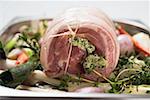 Rolled pork roast with herb stuffing on bed of vegetables