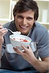 Junger Mann Essen Quark mit frischen Erdbeeren