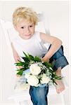 Boy with bouquet of white roses sitting on a chair